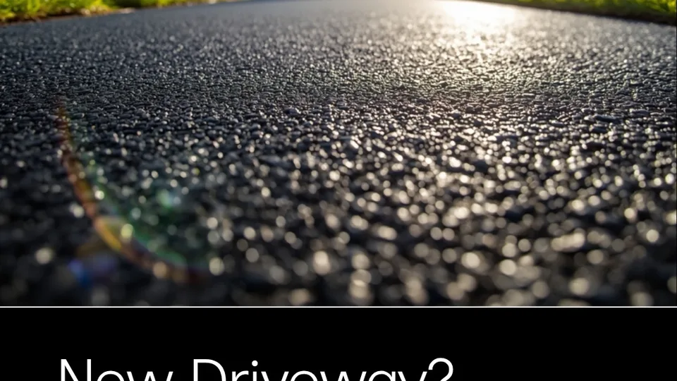 Close-up of a newly finished asphalt driveway meeting a trimmed lawn edge